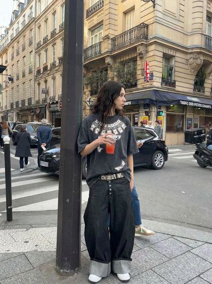 DAXUEN Washed oversized graphic t-shirt with dollar bills and 'misery' print — model photo