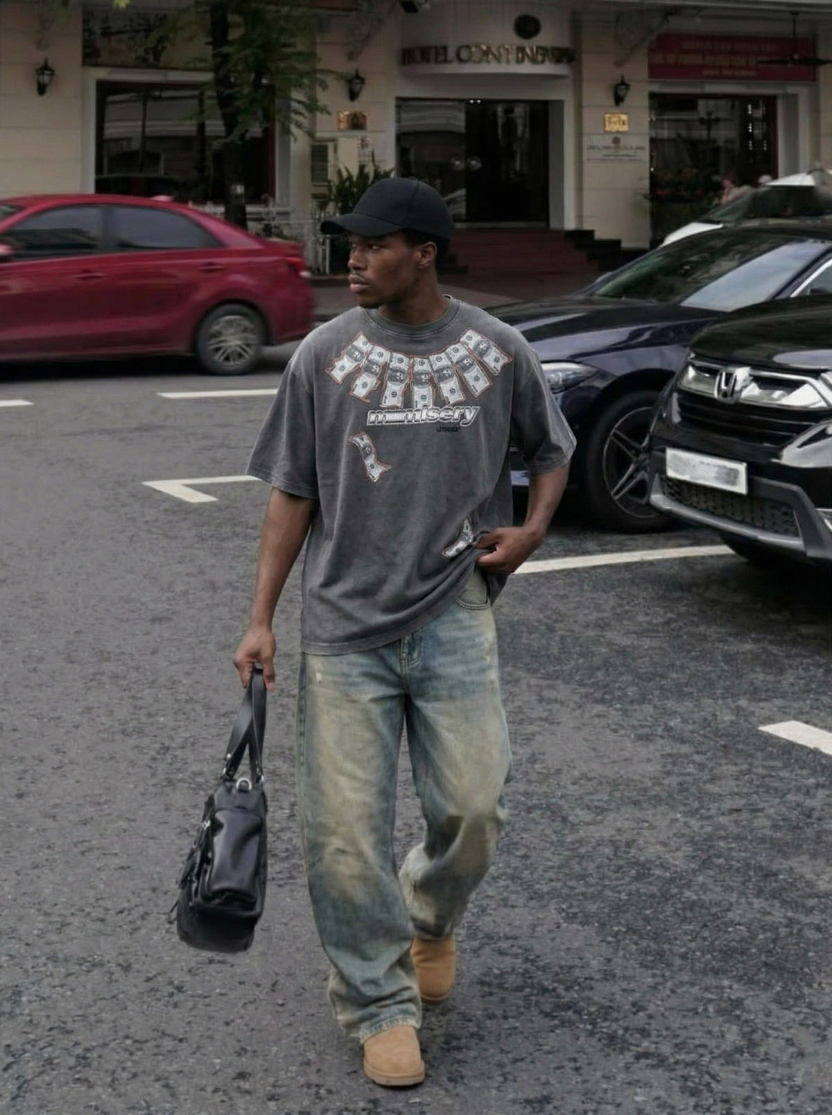 DAXUEN Washed oversized graphic t-shirt with dollar bills and 'misery' print — model photo