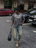 DAXUEN Washed oversized graphic t-shirt with dollar bills and 'misery' print — model photo