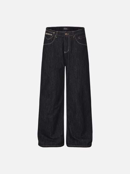 Dark wash wide-leg streetwear jeans with contrast stitching, gold-tone hardware, and script letter embroidery on the back pockets.