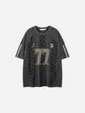 Dark charcoal grey oversized t-shirt with a large number 77 graphic, tonal vertical stripes, and a small shield crest badge on the chest.