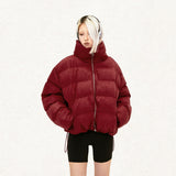 Model wearing the red Solid Color Pleated Padded  jacket  in a gray background 
